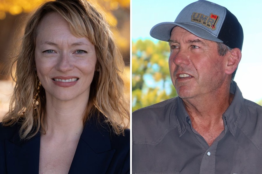 Rebecca Busic, smiling, in a dark blazer in front of yellow autumn leaves, beside Rodney Cox in a gray cap and gray shirt, looking to his right.